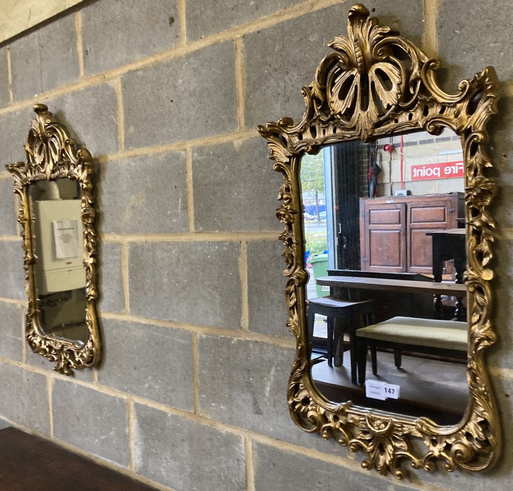 A pair of carved giltwood wall mirrors, with pierced frames, width 48cm, height 85cm